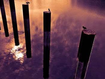 Close-up of wooden posts against sky at sunset