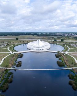 Aerial view of swimming pool by lake against sky