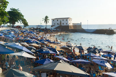 Tourists have fun on the beach of porto da barra postcard of the city of salvador, bahia.
