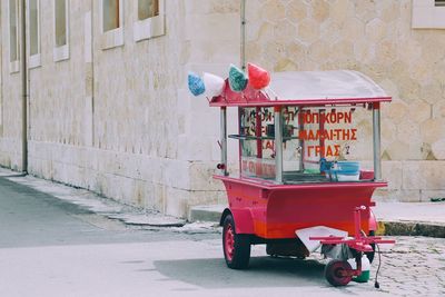 Red cart on street against building