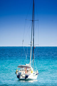 Ship in sea against clear blue sky