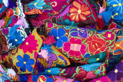 Close up of traditional mexican handmade women's handbags, multicolored floral design.