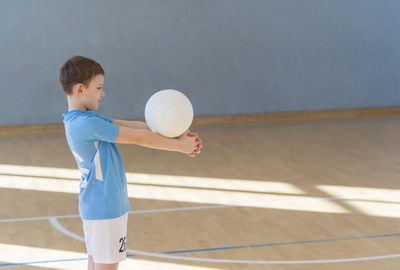 Side view of boy playing volleyball