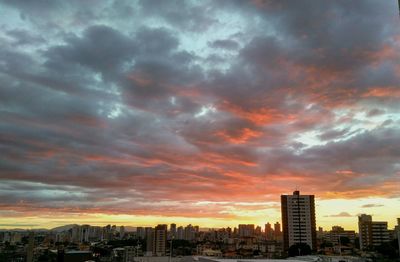 View of cityscape against cloudy sky during sunset