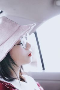 Side view of thoughtful young woman looking away while sitting in car