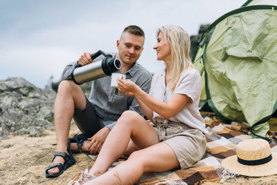 Happy young couple travelers in casual outfits on mountain background. local tourism, weekend trip