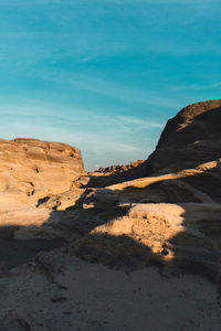 Rock formations on land against blue sky