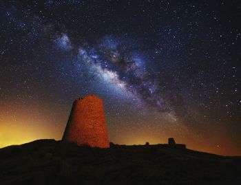 Low angle view of old ruin against star field