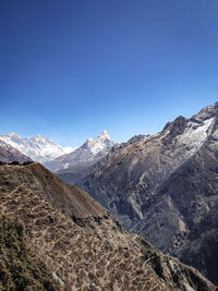 Scenic view of snowcapped mountains against clear blue sky