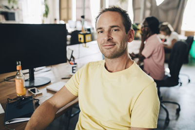 Portrait of confident businessman sitting in creative office