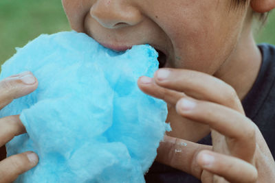 Midsection of boy eating cotton candy