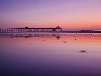 Pier over sea against sky during sunset