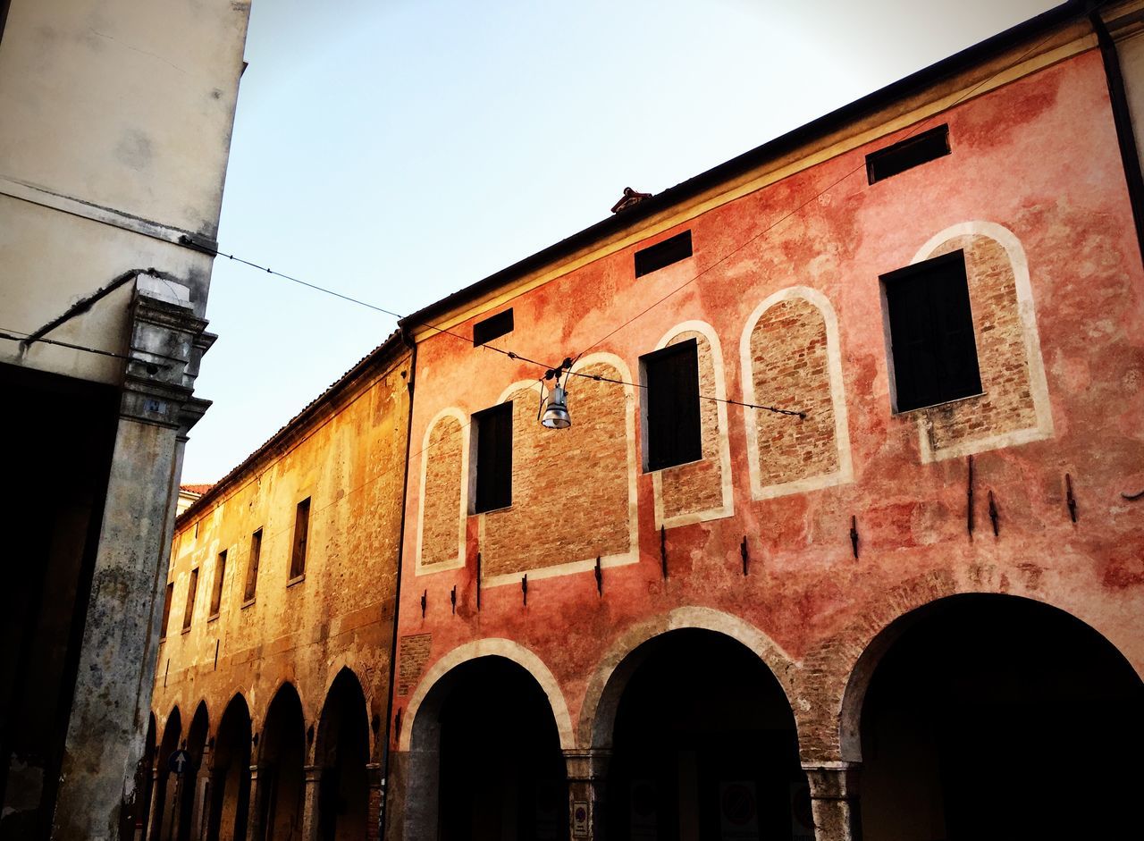 architecture, built structure, building exterior, window, low angle view, arch, brick wall, old, building, weathered, sky, residential building, wall - building feature, wall, outdoors, no people, clear sky, day, residential structure, abandoned