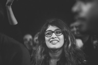 Close-up of smiling woman wearing eyeglasses looking away