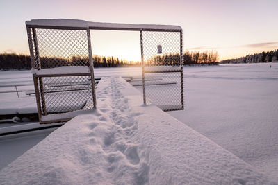 Scenic view of frozen lake against sky during sunset