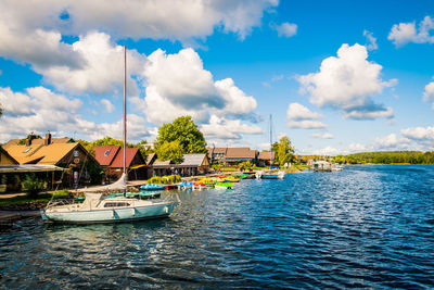 Sailboats moored in lake against sky