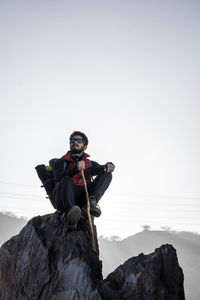 Man sitting on rock against sea