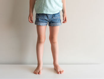 Low section of woman standing against white background