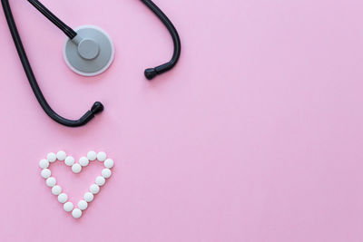 High angle view of heart shape on pink over white background