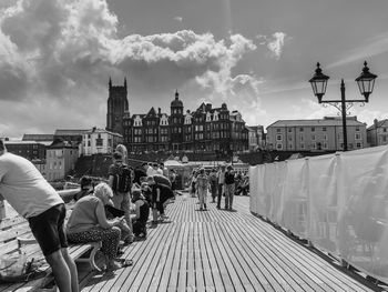 People in city buildings against sky