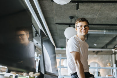 Portrait of smiling young computer programmer at tech startup office