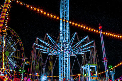 Low angle view of illuminated ferris wheel against sky at night