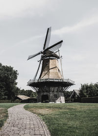 Traditional windmill on field against sky