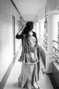 Rear view of woman standing in corridor