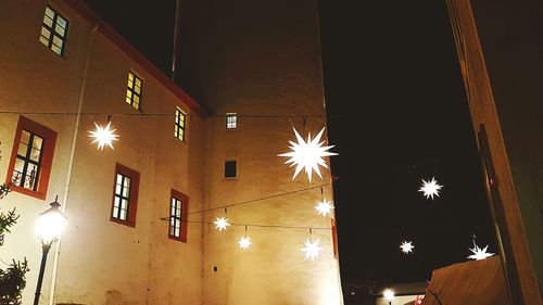 Low angle view of illuminated lamp against sky at night