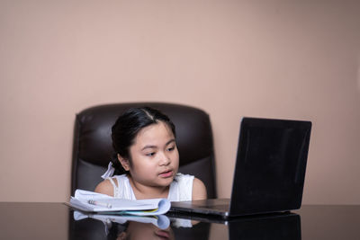 Portrait of girl sitting on table