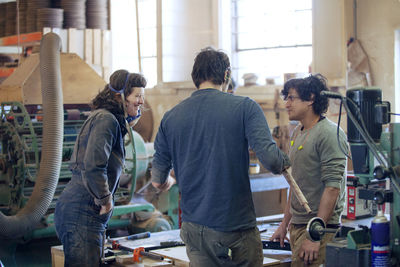 Carpenters discussing in workshop
