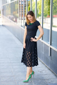 Portrait of young woman standing in city