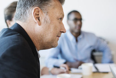 Mature businessman concentrating in meeting at board room