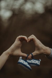 Cropped hands of couple holding baby booties