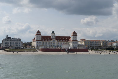 Buildings by sea against sky in city