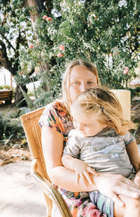 Mother and daughter sitting outdoors