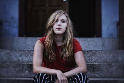 Portrait of young woman sitting on steps