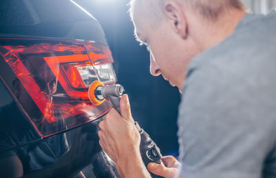 Side view of man repairing car