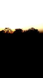 Silhouette landscape against clear sky during sunset