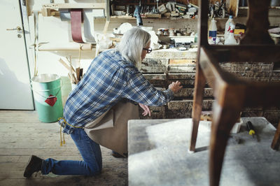 Side view of woman sitting on floor