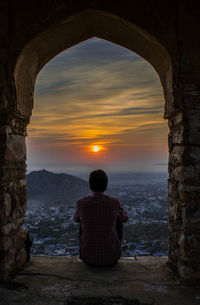 Rear view of man standing at sunset