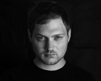 Close-up portrait of young man against black background