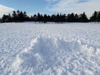 Snow covered field against sky