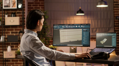 Side view of man using laptop at office