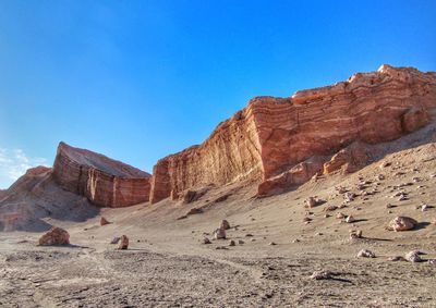 Rock formations on mountain against blue sky