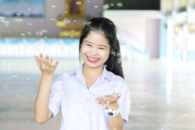 Portrait of smiling young woman standing outdoors
