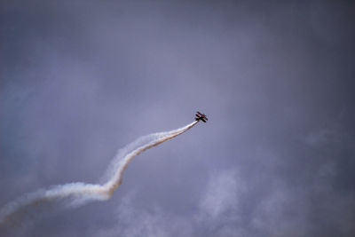 Low angle view of airplane flying against sky