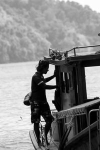 Man standing on boat against sea