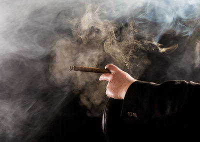 Cropped image of man smoking cigar