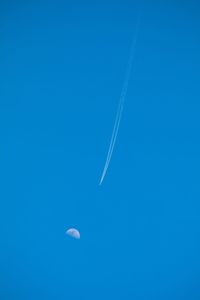 Low angle view of vapor trail against blue sky